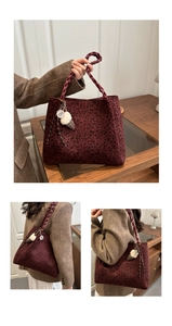 Detail of burgundy leopard tote bag with woven handles and plush ice cream charm