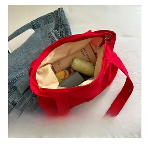 Vista interna che mostra la grande capacità per libri e ombrelli della borsa rossa
