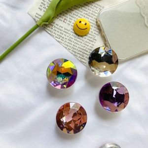 Close-up of faceted gemstone phone socket grips in iridescent purple and champagne colors