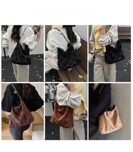 Quilted bucket bag detail showing contrast stitching and metal chain shoulder straps