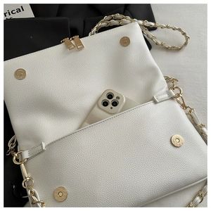 Internal view of white litchi pattern chain bag showing smartphone capacity and metal clasp