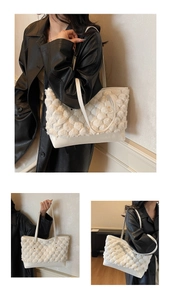 Close-up of white plush bucket bag showing soft pom-pom texture and faux leather straps