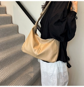 Détail d'un sac bandoulière en cuir PU beige avec coutures verticales et sangle réglable