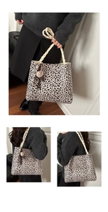 Detail of leopard print tote bag featuring woven rope handles and a cute bear charm