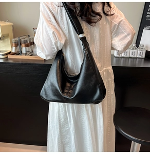 Détail du sac hobo noir avec bandoulière réglable et boucle métallique dorée élégante