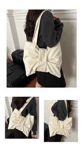 Detailed close-up of cream white nylon tote bag with large decorative bow design