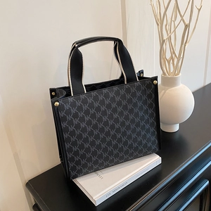 Large black tote bag featuring gray NK monogram pattern and gold metal hardware