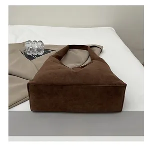 Close-up of durable wear-resistant base on a large brown suede tote shoulder bag