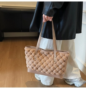 Detail of khaki plush tote bag featuring spherical quilting and premium leather base