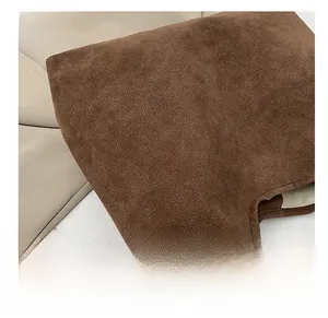 Close-up of deep brown suede tote bag showing premium fabric texture and fine stitching