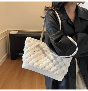 Detail of white tote bag with textured plush stitching and smooth leather bottom