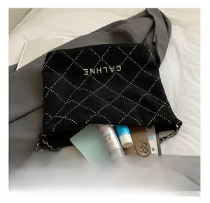 Detailed internal view of black quilted tote bag holding a tablet and cosmetics