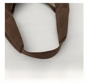 Detail view of a wide coffee-colored suede shoulder strap with precise edge stitching