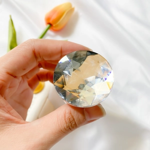 Close-up of a faceted crystal phone grip with a silver base on white fabric background