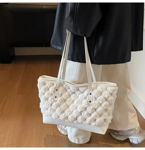 Dettaglio della borsa tote bianca trapuntata con texture a bolle e base liscia