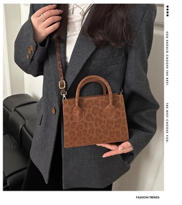Detail view of the brown leopard print handbag with metallic buckle and shoulder strap