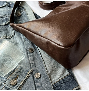 Gros plan sur un sac cabas en cuir marron foncé au design rétro et minimaliste