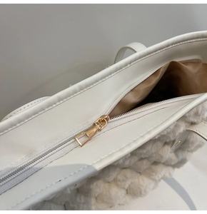 Dettaglio della texture in peluche bianco e cerniera dorata della borsa a secchiello
