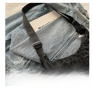 Close-up of black leopard jacquard fabric and adjustable strap buckle on a square bag
