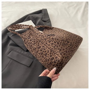Detail of leopard print tote bag with brown braided leather handle and side drawstring