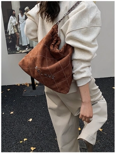 Detail of brown suede shoulder bag featuring diamond quilting and fine bead embellishments