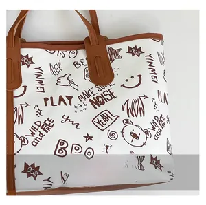 Detailansicht der weißen Graffiti-Tasche mit braunen Ledergriffen und Sternmustern