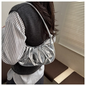 Vista dettagliata della borsa a mezzaluna metallizzata argento con finitura lucida e tracolla
