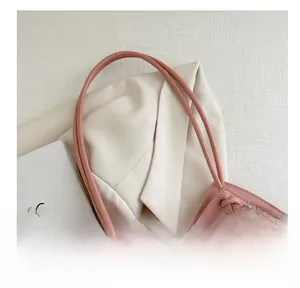 Detail of pink leather handles and cherry print on a transparent PVC tote bag