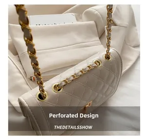 Detail view of the beige quilted crossbody bag with gold metal grommets and chain strap