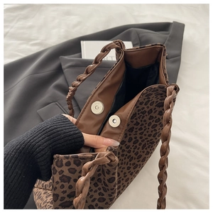 Detail of leopard print tote bag with silver magnetic snap closure and woven strap