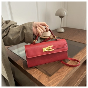 Detailed close-up of a vibrant red crossbody bag featuring gold metal clasp and cross pattern leather