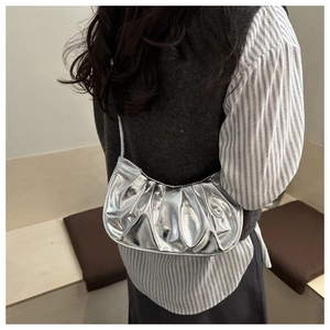 Dettaglio della borsa hobo metallizzata argento con texture plissettata e forma a luna
