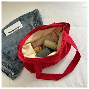 Detailed interior of a spacious red nylon tote bag showing high storage capacity