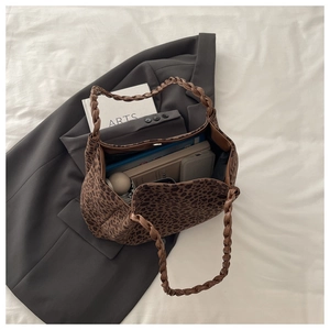 Detailed close-up of leopard print tote bag with woven handles showing large interior capacity