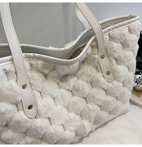 Dettaglio della borsa tote in peluche bianco crema con trama trapuntata e borchie dorate