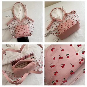 Detailed view of clear PVC tote with cherry print and pink inner zipper pouch storage