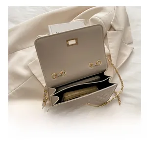 Detail showing internal capacity of beige quilted chain bag with phone and wallet inside