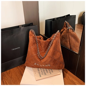 Detail of brown suede hobo bag with diamond stitching and silver chain strap