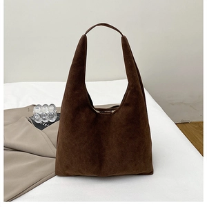 Close-up view of a large dark brown suede tote bag with minimalist shoulder strap design