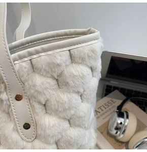 Dettaglio borsa tote in pelliccia sintetica trapuntata crema con borchie dorate