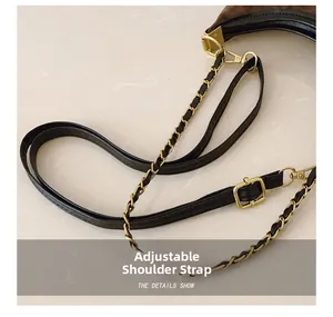 Detail of adjustable black leather strap and gold chain on a leopard print handbag