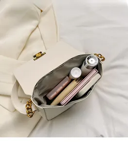 Interior view showing the large capacity and herringbone lining of the white chain bag
