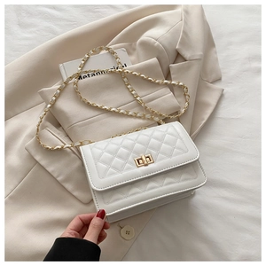 Close-up of white quilted chain bag with gold rectangular clasp and elegant leather-woven chain