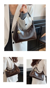Detailweergave van donkerbruine hobo-tas van oliewasleer met gouden bedel en logo