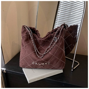 Detail of brown suede shoulder bag with silver studded quilted pattern and chain strap
