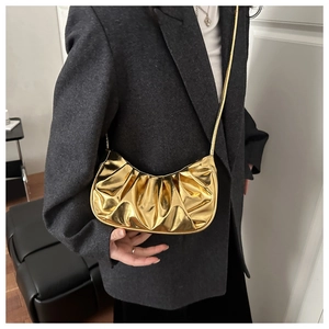 Dettaglio della borsa a nuvola plissettata oro metallizzato con texture lucida