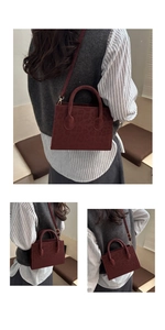 Detail of burgundy leopard print handbag with golden hardware and round handles