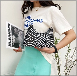 Fashionable zebra print underarm baguette bag shown on a model with white T-shirt