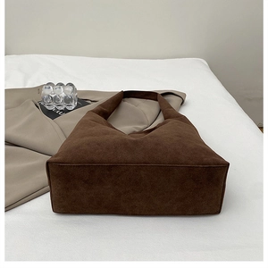 Detail of premium brown suede hobo tote showing fine texture and seamless shoulder strap