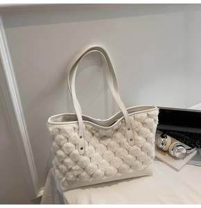Dettaglio della borsa a spalla in pile bianco con finiture in pelle e cinghie